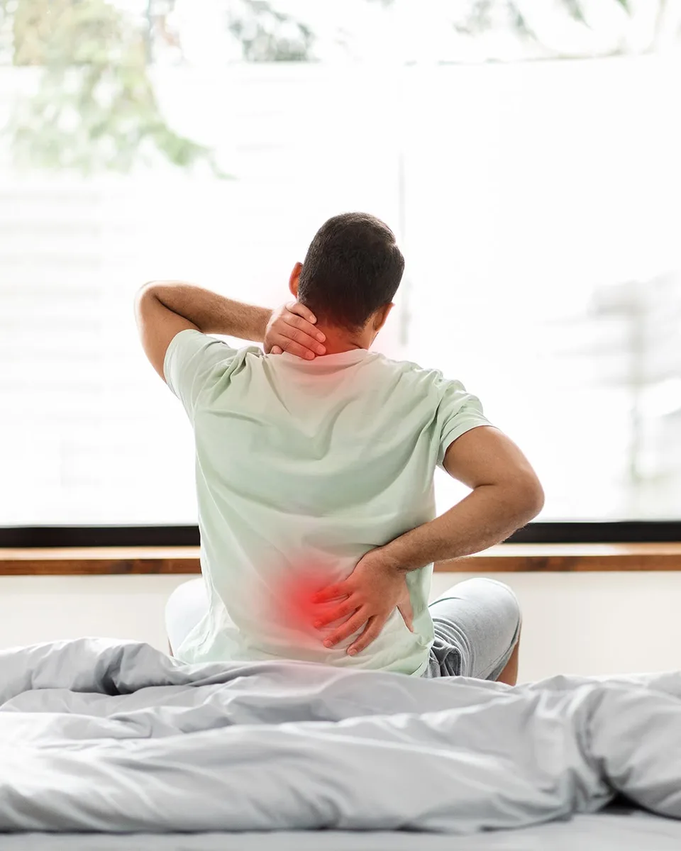 Person holding their neck and lower back where they feel pain